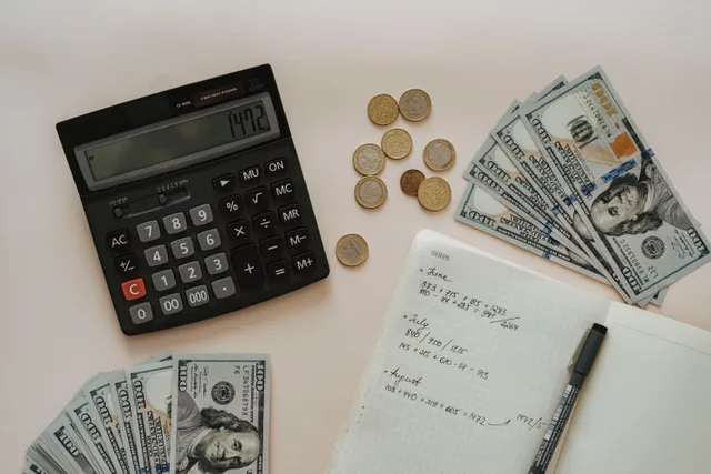 Flat lay of calculator, cash, coins, and handwritten notes for budget planning. Advertising tools for franchises should be scored on fund controls and vendor exit