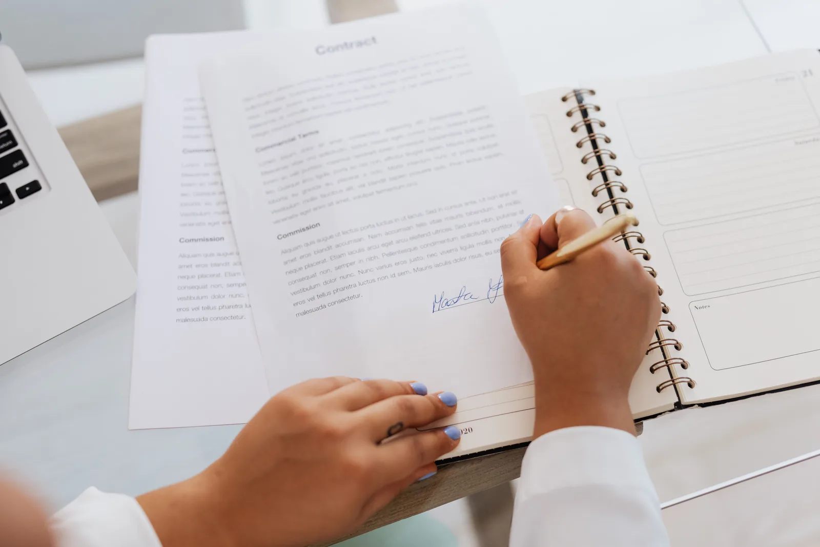 Close-up of hands signing a contract on a desk with office supplies, symbolizing legal agreements. Franchise email marketing trends: hypotheses to test