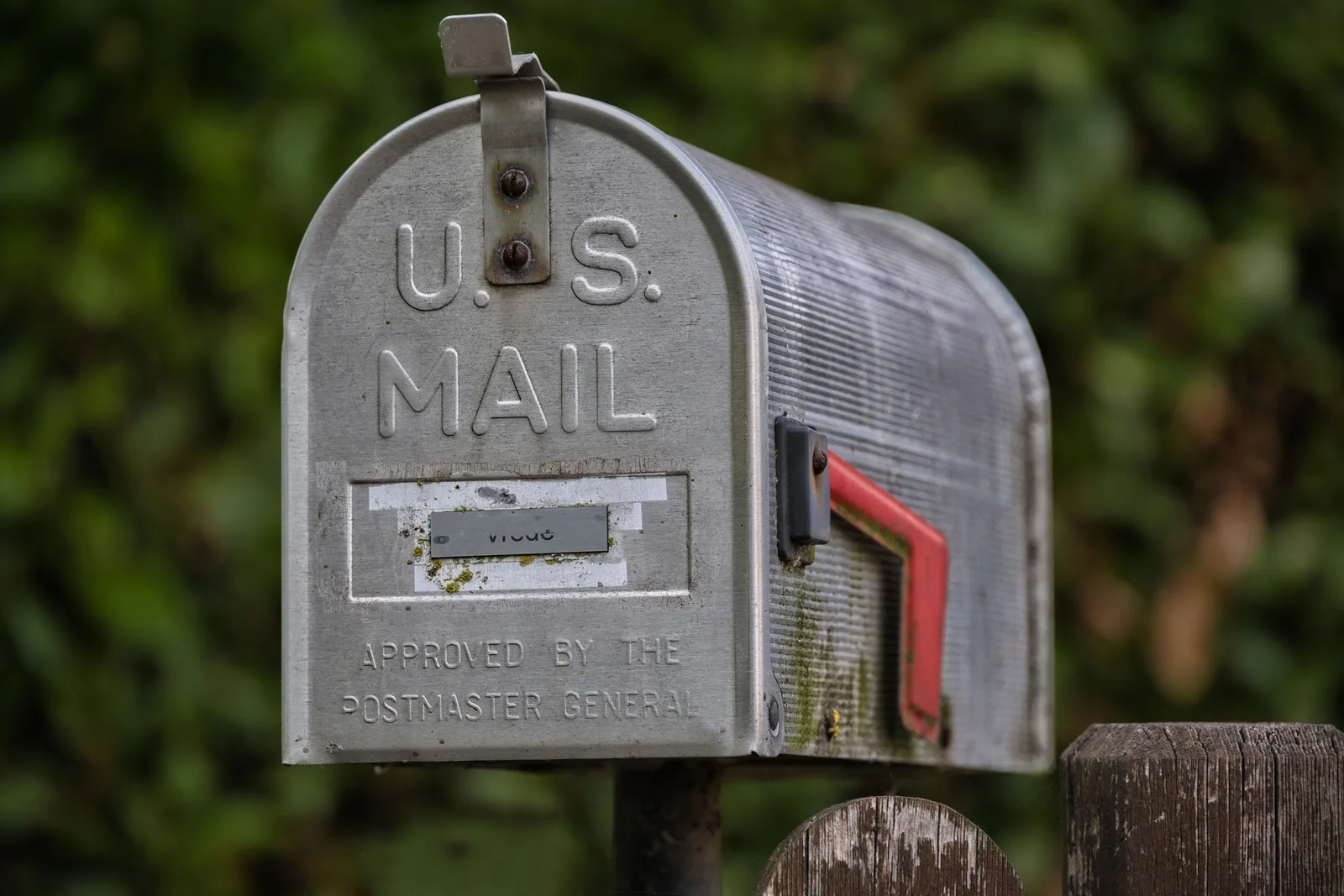 Close-up of a classic U.S. mailbox on a rustic wooden post, outdoors. Franchise email marketing: find the failed stage and run a controlled repair