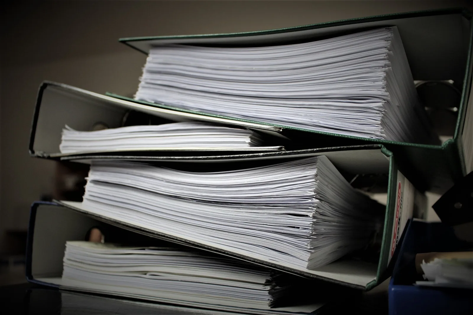 Close-up of stacked binders filled with documents for office or educational use. Anecdote versus evidence in local franchise marketing case reviews